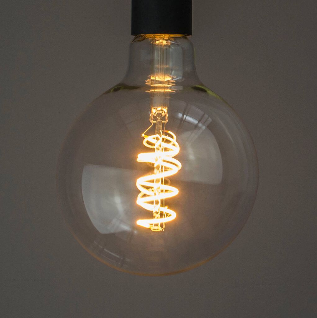 A close-up shot of a vintage-style LED light bulb with a spiral filament.