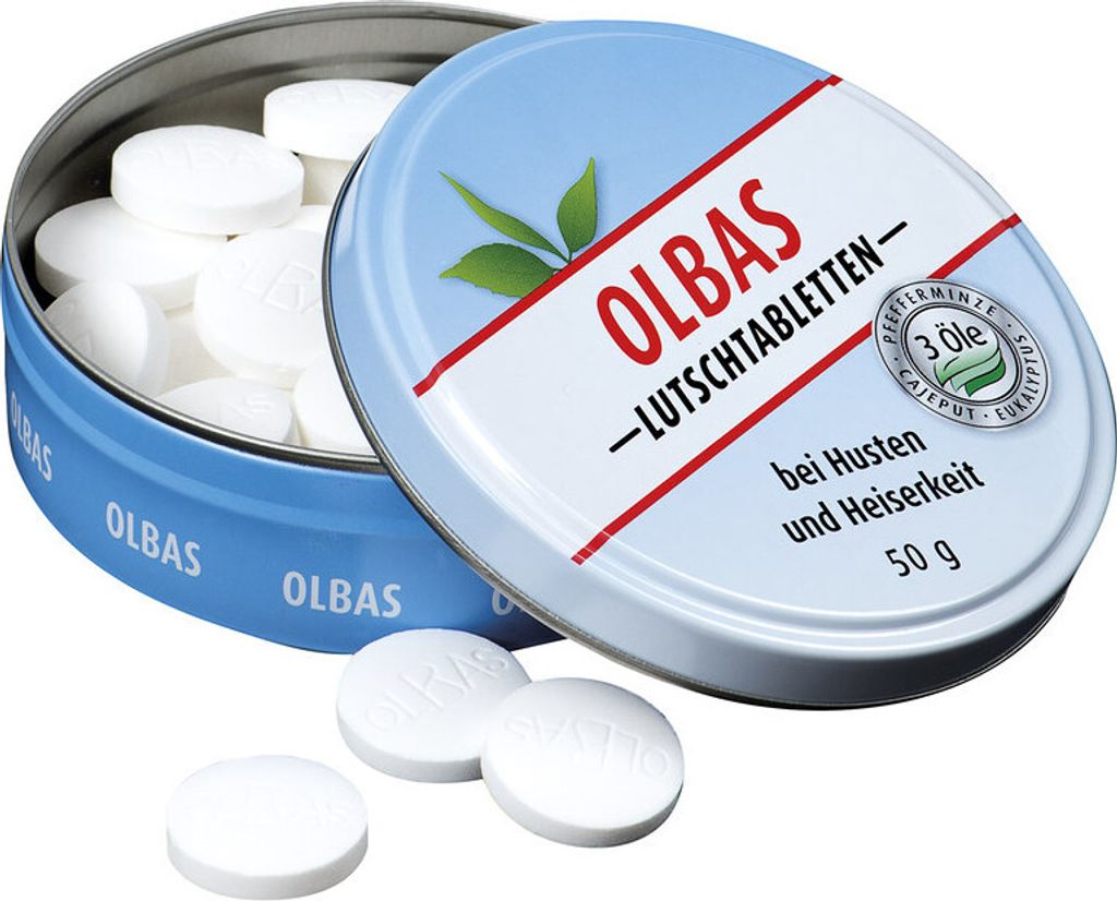 A tin of Olbas lozenges with some lozenges scattered in front.