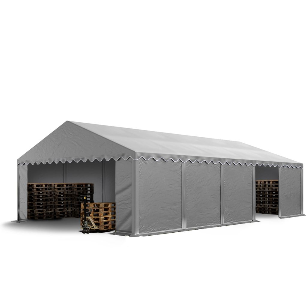 A grey industrial tent with wooden pallets inside and outside.