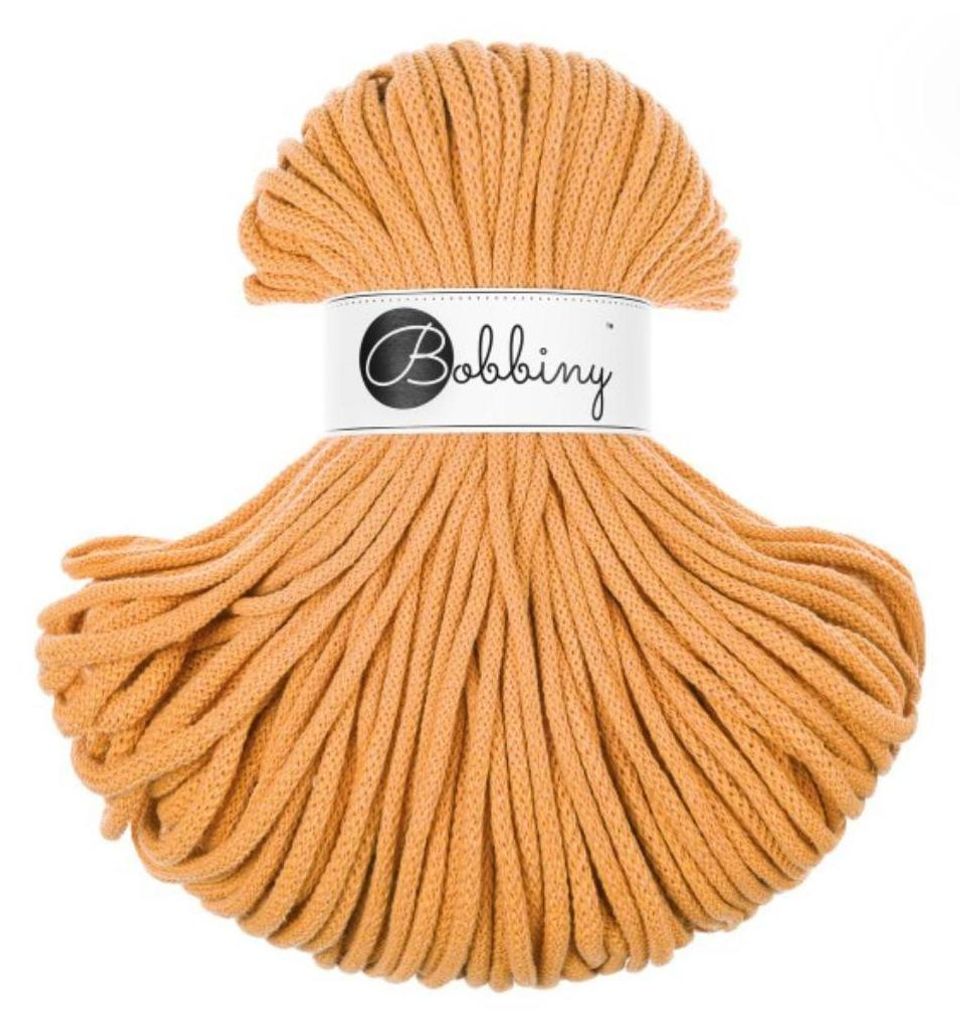 A ball of orange yarn with a label around the middle.
