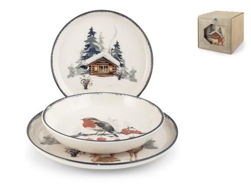 A set of dinnerware with a winter cabin and animal theme, including a plate, bowl, and another plate, along with a small box in the background.