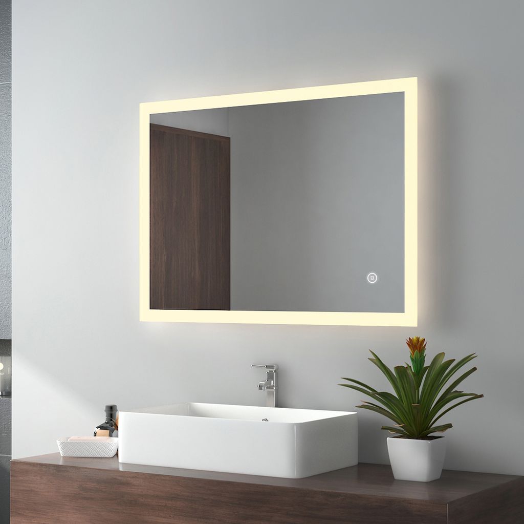 A modern bathroom vanity with a rectangular sink, a faucet, and a large illuminated mirror above it. A small potted plant sits on the counter to the right of the sink.