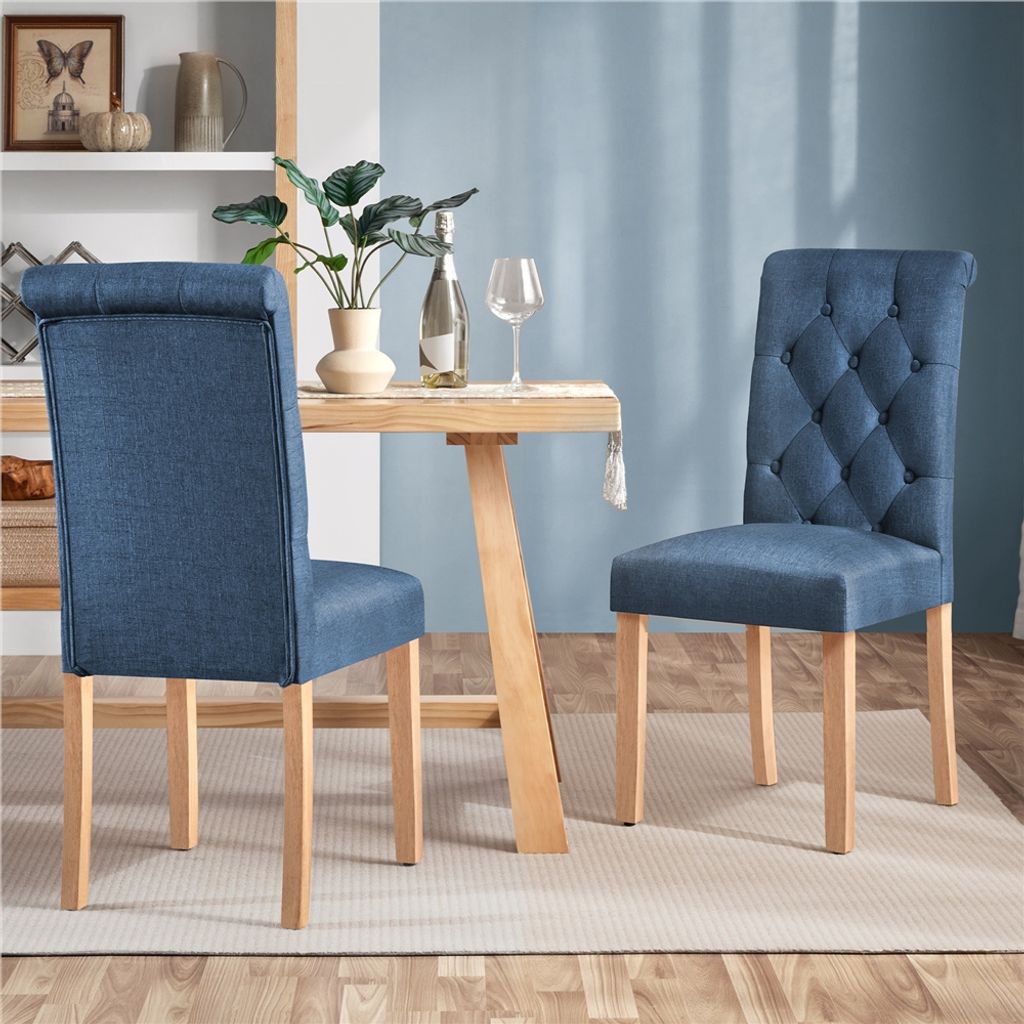 Two blue dining chairs are placed around a wooden dining table in a room with a blue wall.