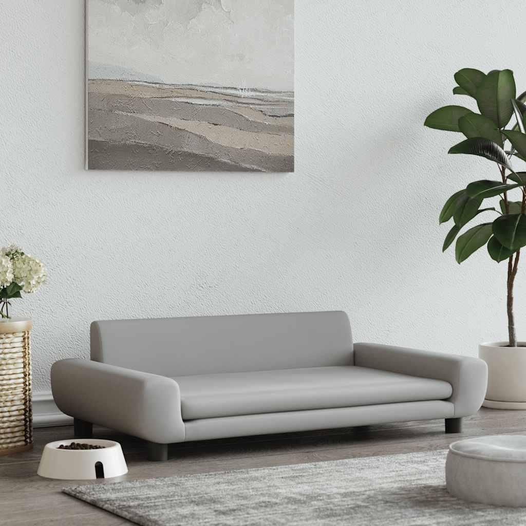 A modern living room setting with a grey dog sofa, a plant, and a painting on the wall.