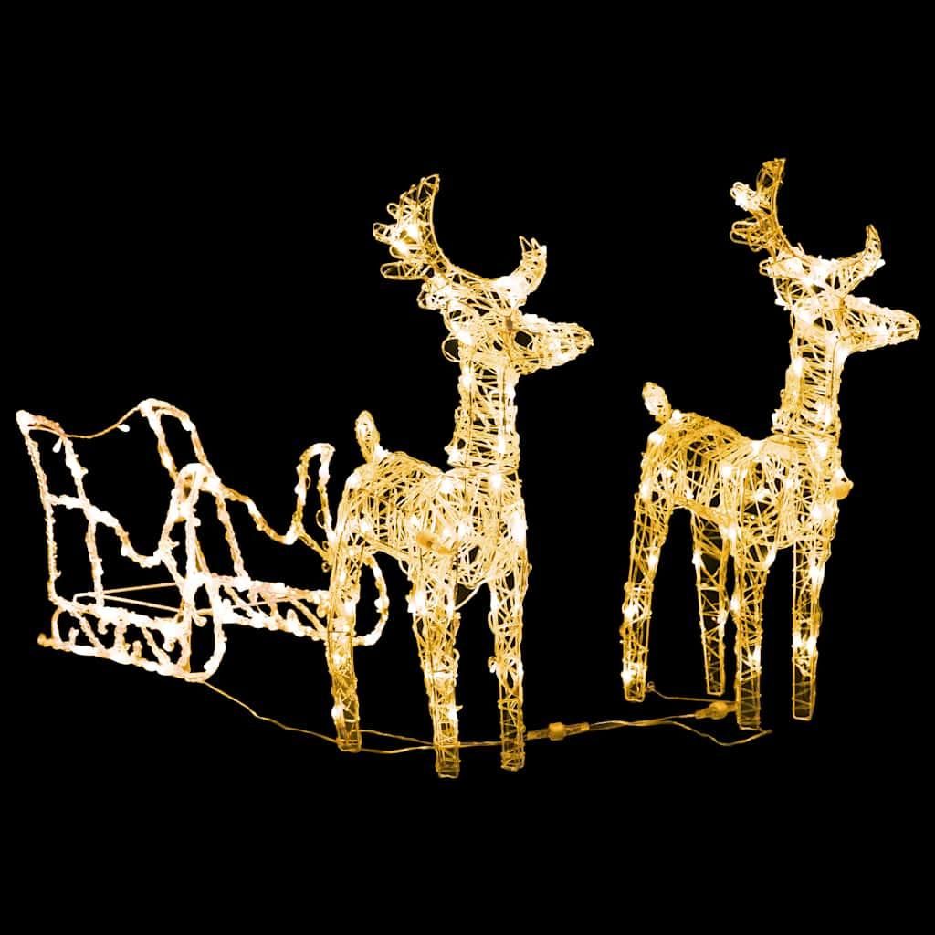 A lighted Christmas decoration of a sleigh and two reindeer on a black background.