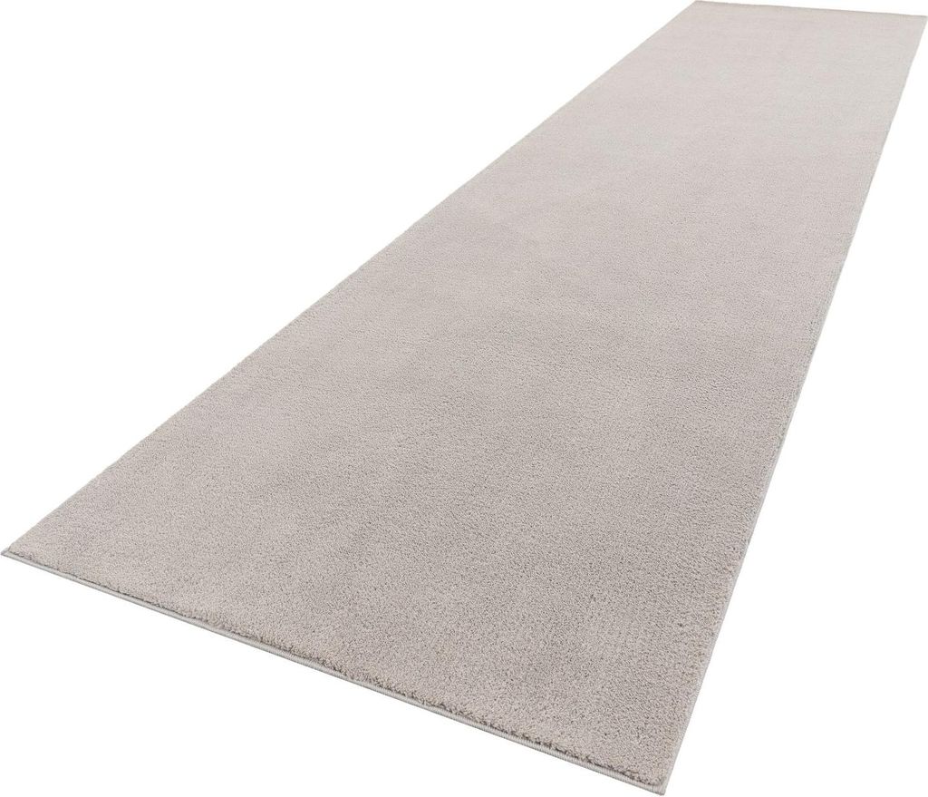 A long, narrow, light gray rug is shown from a diagonal, slightly elevated perspective against a white background.