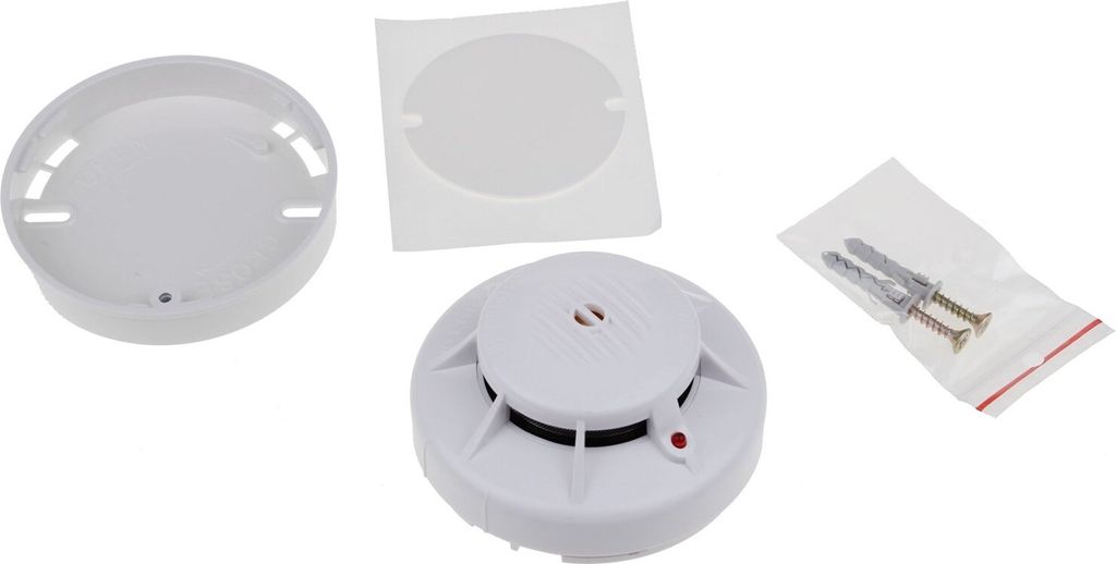 A white smoke detector and its accessories are laid out on a white background.
