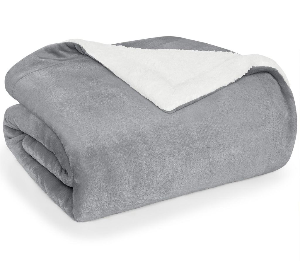 A folded gray blanket with a white sherpa lining is shown on a white background.