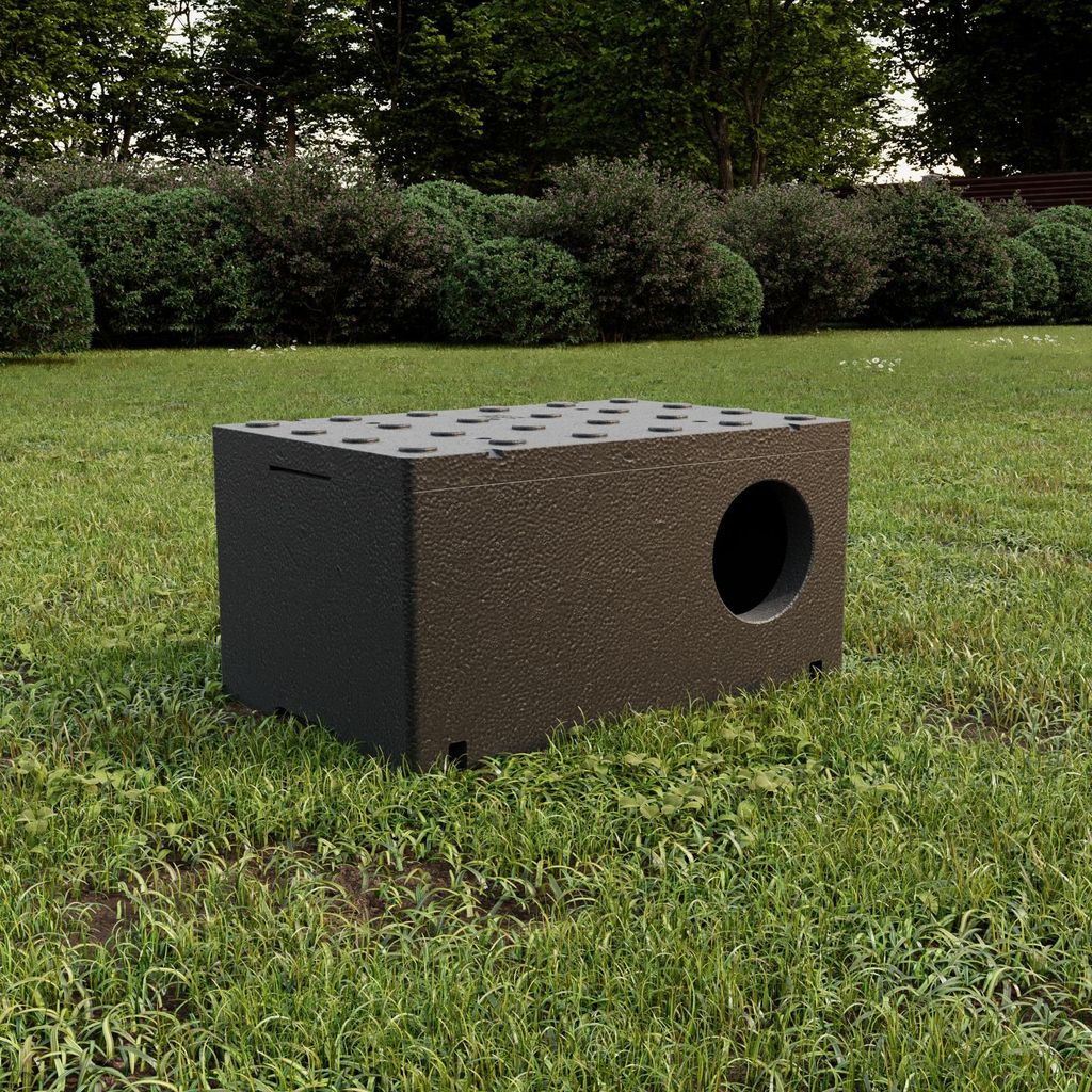 A dark brown insulated cat house sits on a grassy lawn with bushes and trees in the background.
