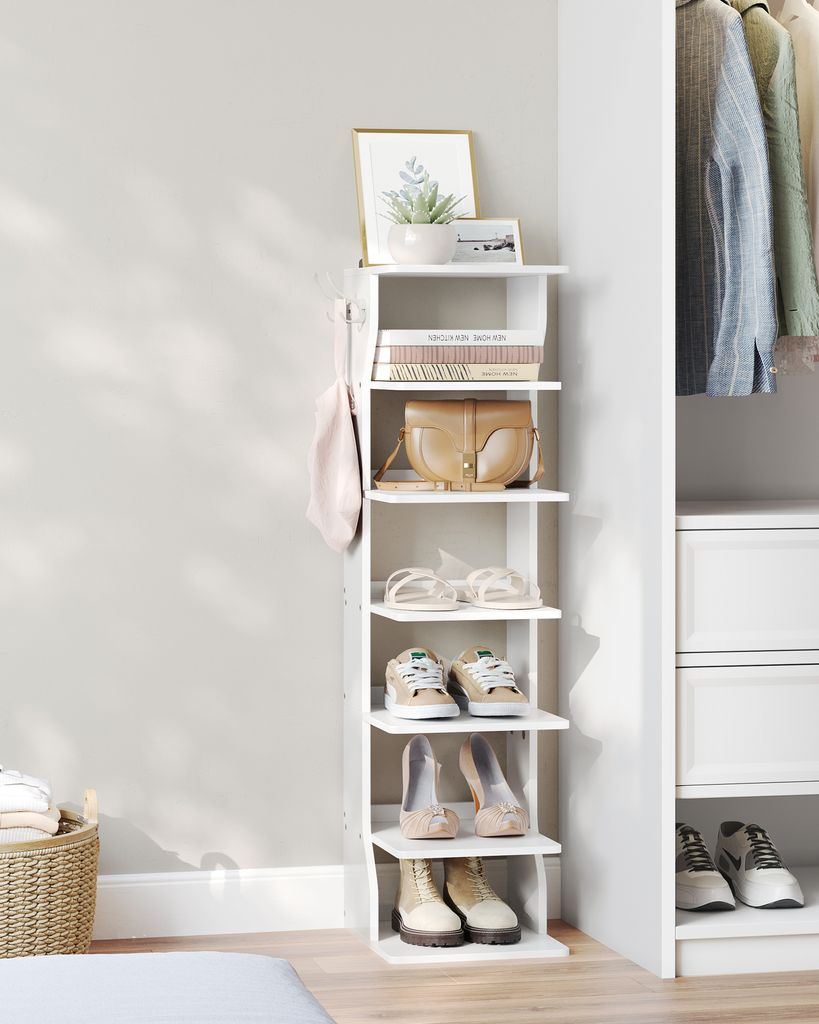 A white multi-tiered shelf unit displaying shoes, bags, and decorative items, next to a closet filled with clothes. A woven basket with folded items is also visible.