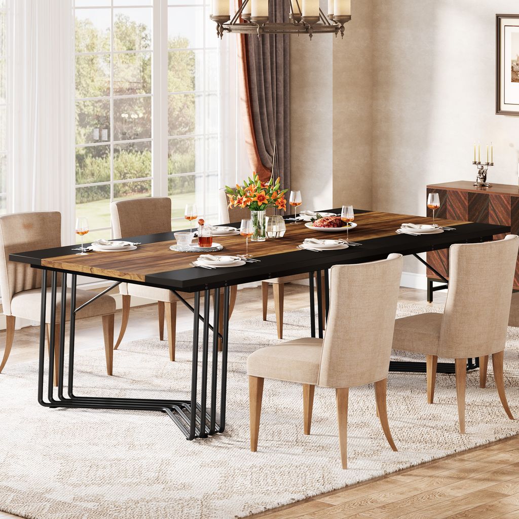 A dining room scene with a large wooden dining table set for a meal, surrounded by chairs, with a chandelier overhead and a large window in the background.