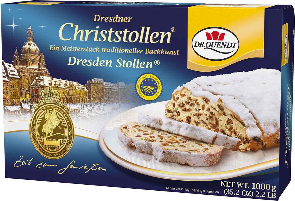 A box of Dresdner Christstollen with a slice of the cake shown on a plate.