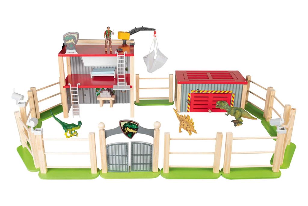 A toy dinosaur enclosure playset with wooden fences, buildings, and dinosaur figures.