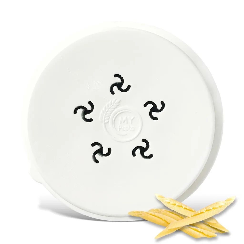A white lid with a pasta maker attachment and some dried pasta pieces.