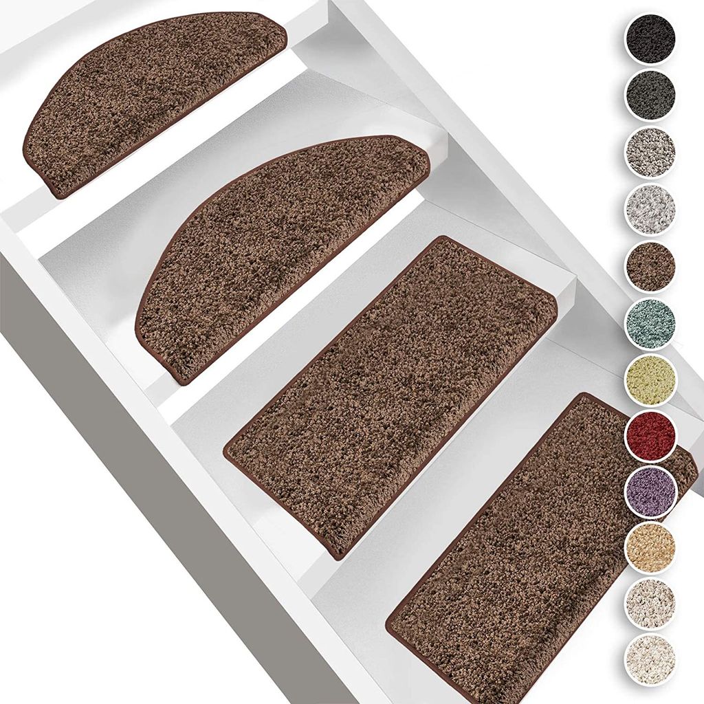 Several brown stair mats are placed on white stairs.