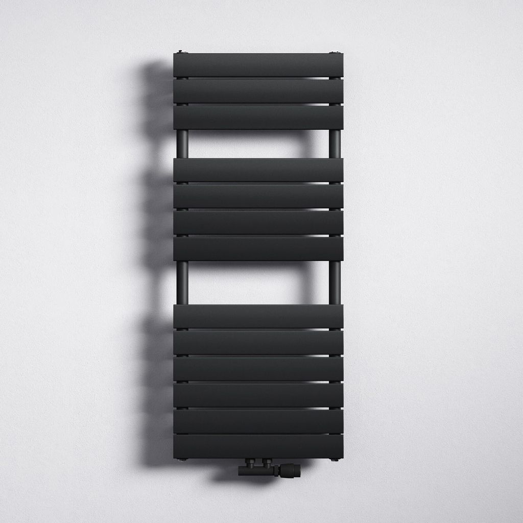 A black radiator is mounted on a white wall.