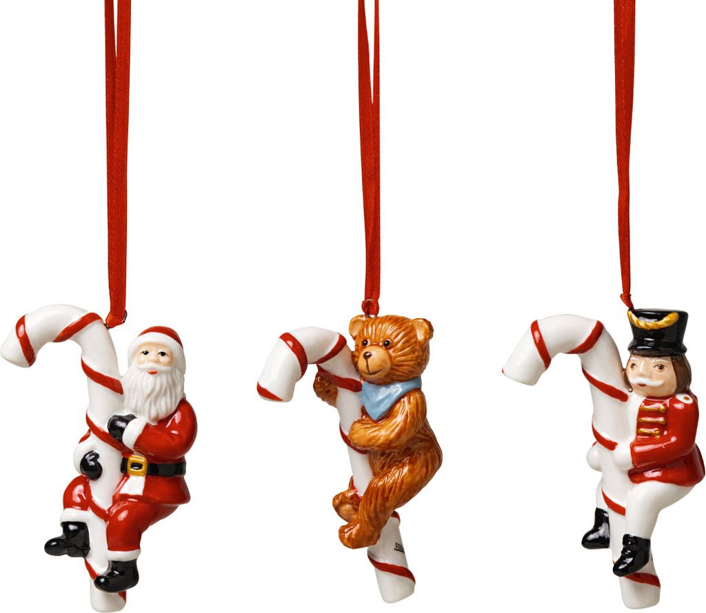 Three Christmas ornaments hanging from red ribbons against a white background.