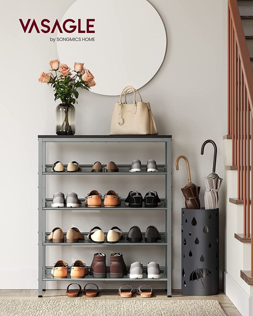 An entryway with a shoe rack, vase of flowers, handbag, and umbrella stand.