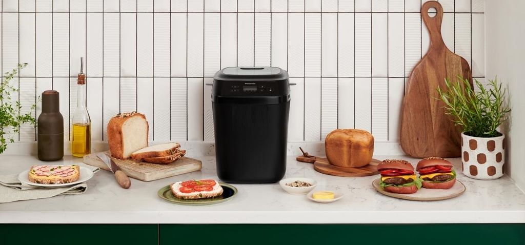 A kitchen counter with a bread maker and various bread products.