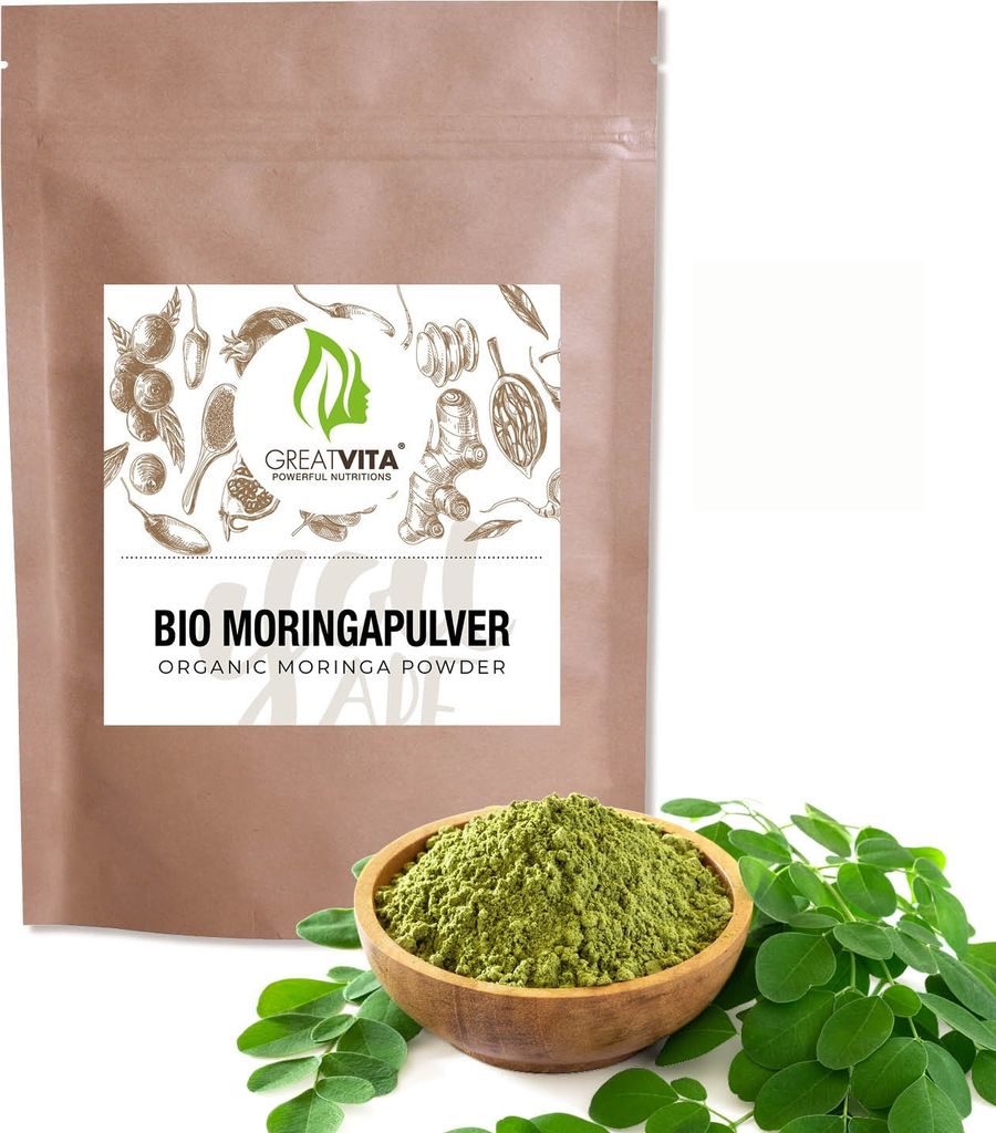 A bag of moringa powder with a bowl of moringa powder and leaves in front of it.