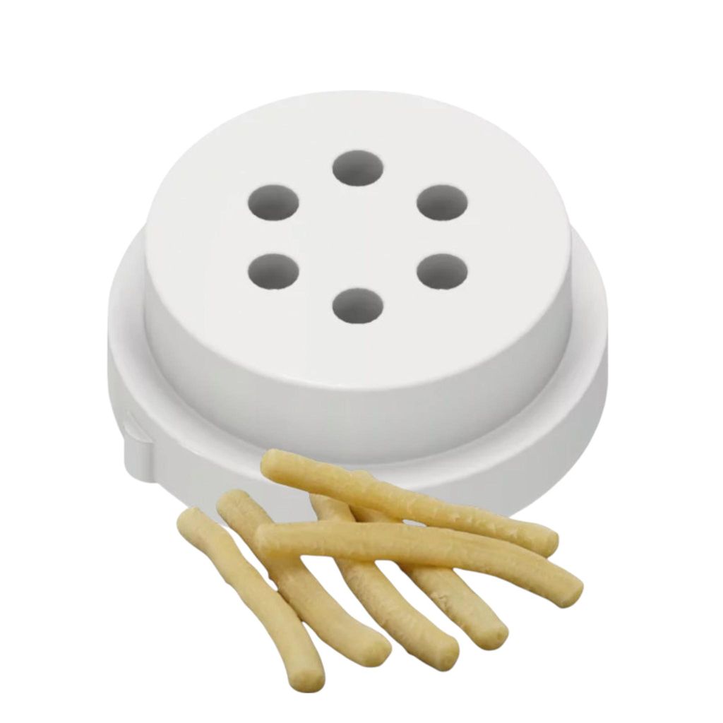 A white pasta maker disk with several small holes and a few grissini (breadsticks) in front of it.