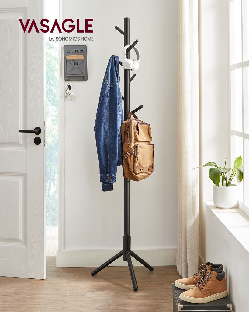 A hallway scene showing a black coat rack with a jacket, backpack, and headphones on it, near a door and a window with curtains.