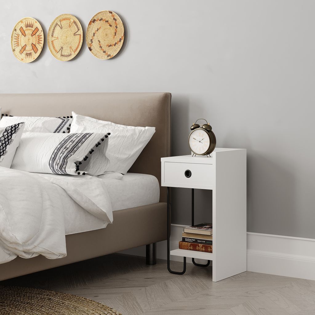 A bedroom scene with a bed, nightstand, and wall decor.