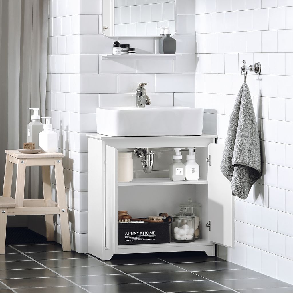 A white bathroom vanity with a sink and various bathroom accessories.
