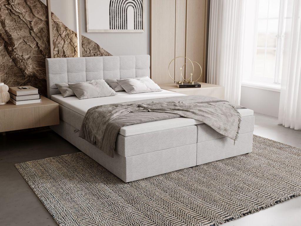 A bedroom scene featuring a light gray upholstered bed with storage.
