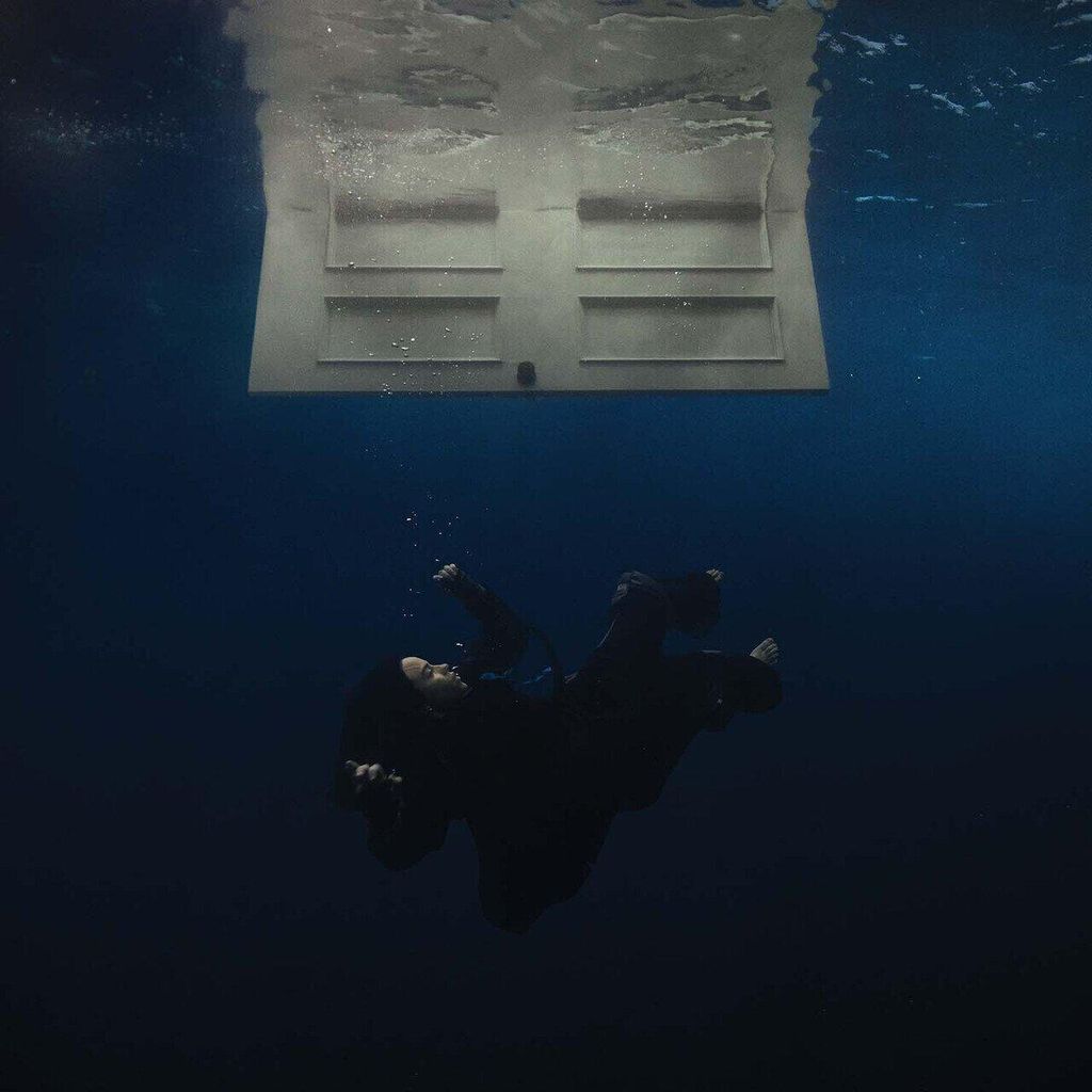A person is shown underwater, seemingly falling, with a door floating above them.