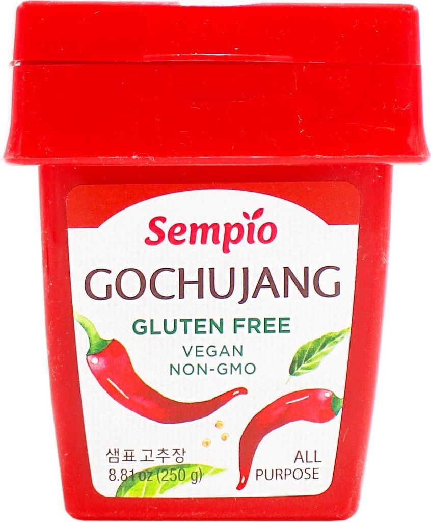 A red container of Sempio Gochujang with a label showing chili peppers and text.