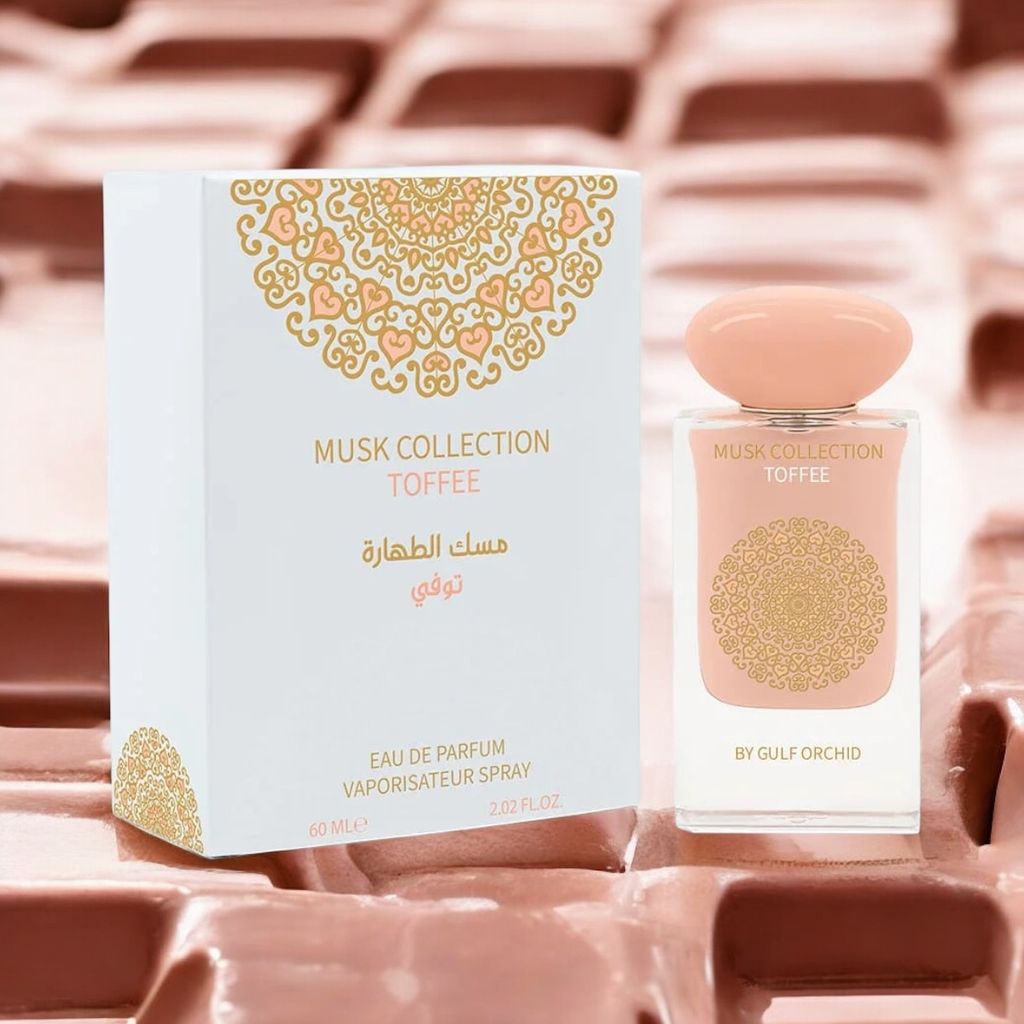 A perfume bottle and its box are displayed on a textured pink and brown surface.