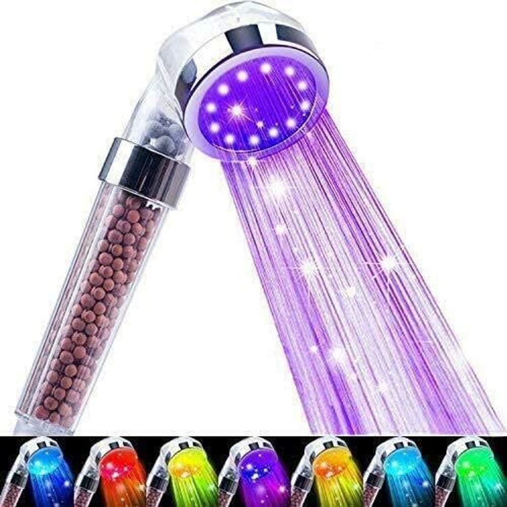 A close-up of a shower head with purple LED lights and water spraying out.