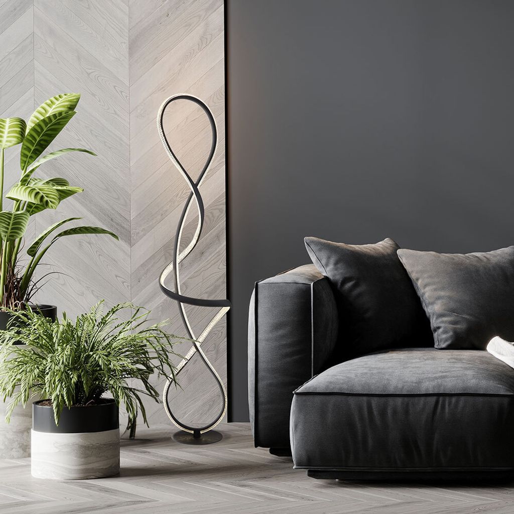 A modern living room with a sofa, plants, and a unique floor lamp.