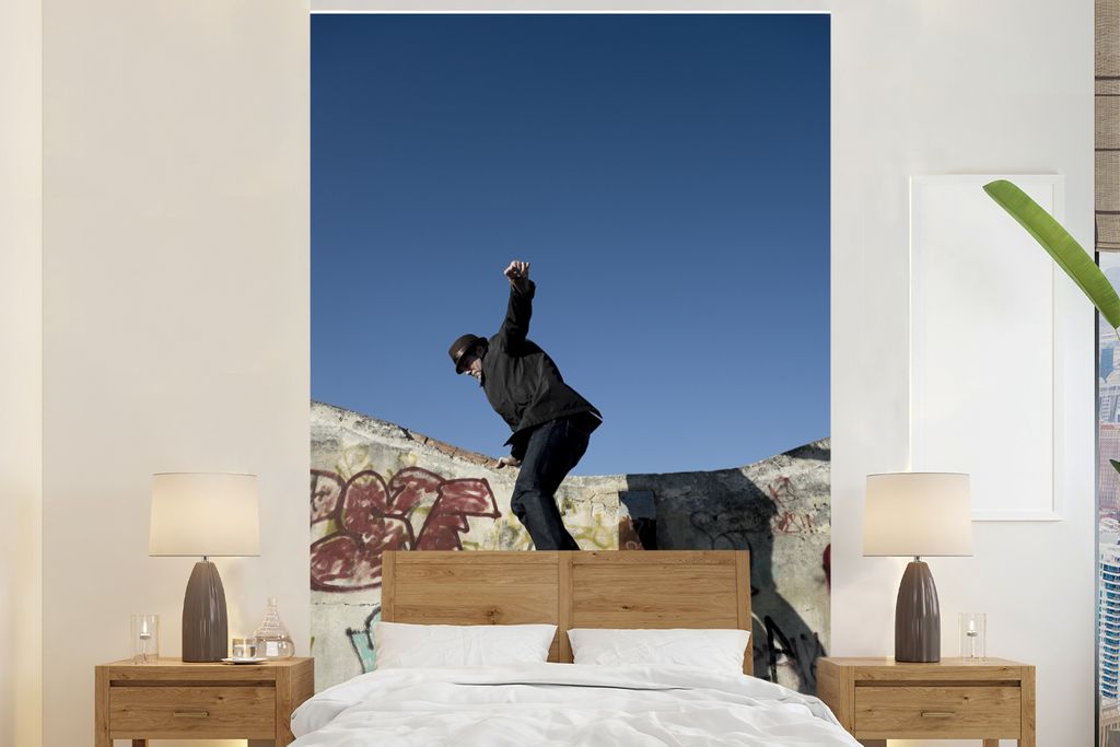 MuchoWow Fototapete für Wohnzimmer oder Schlafzimmer Wandtapete Vinyl Motivtapete Eine Person, die als Freerunner von einem Gebäude springt - 1...
