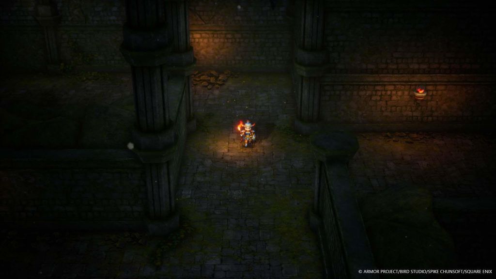 A character in a video game is walking down a dark, stone corridor.