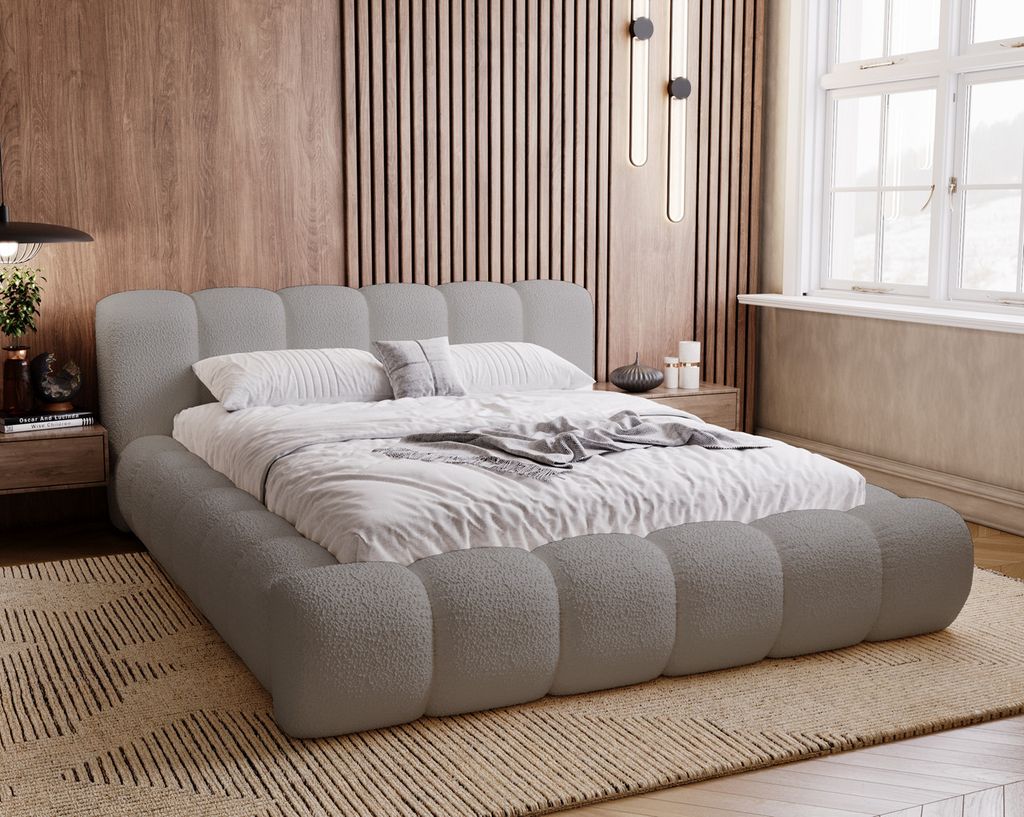 A modern bedroom with a plush grey bed.