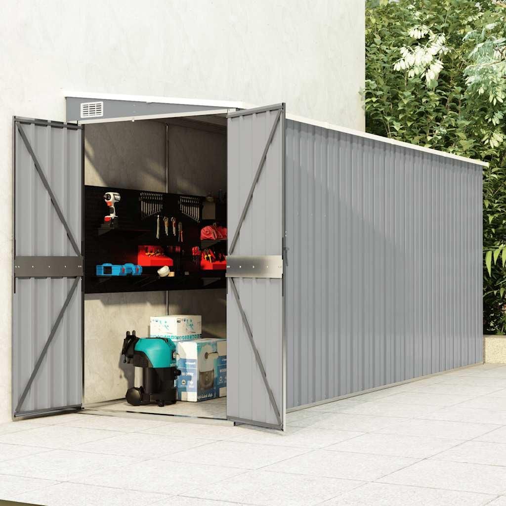 An outdoor storage shed with its doors open, revealing tools and storage boxes inside.