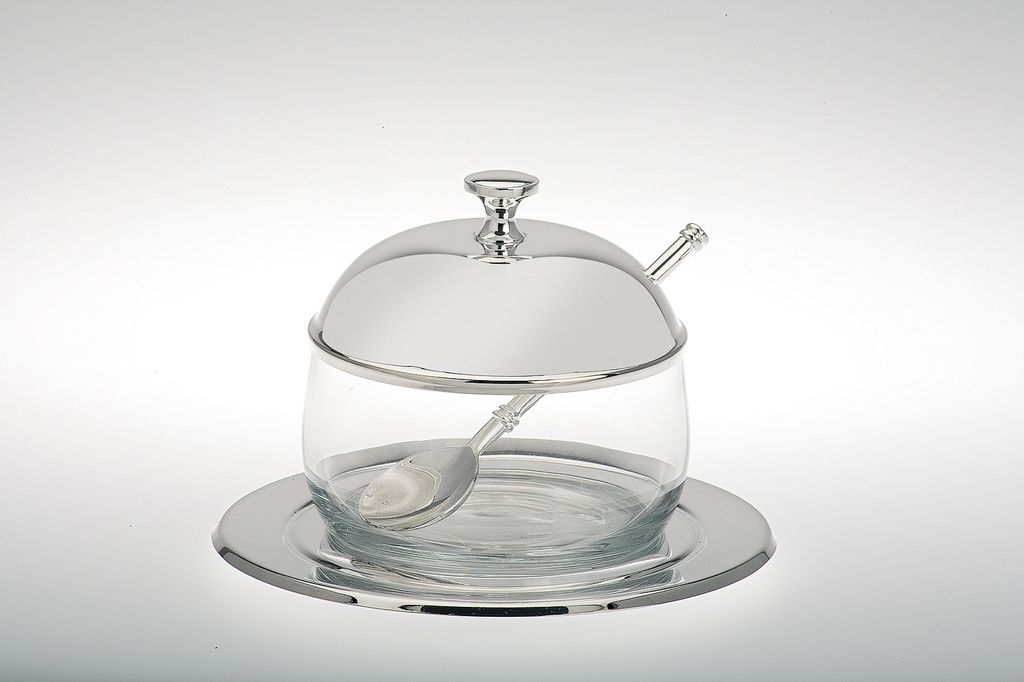 A silver-plated glass jam jar with a spoon and saucer, presented on a plain white background.