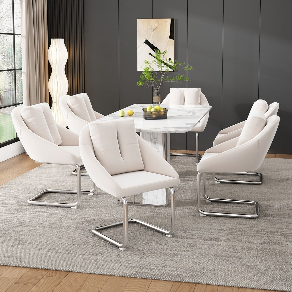 A dining room setting with a marble-topped dining table and six beige upholstered chairs.