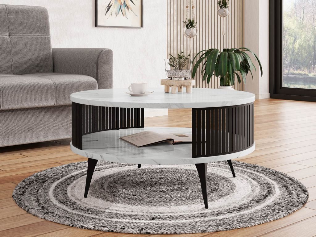 A modern living room scene featuring a round coffee table with a marble top and black metal slatted sides, placed on a circular rug in front of a gray sofa.