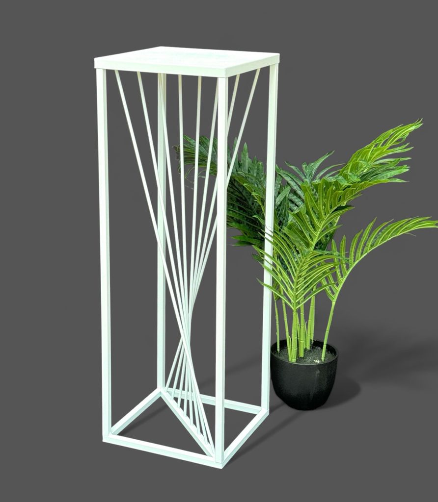 A white metal plant stand with a twisted design is shown next to a potted green plant.