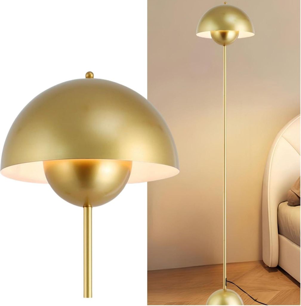 A close-up of a golden floor lamp with a parabolic shade, placed next to a bed in a bedroom.