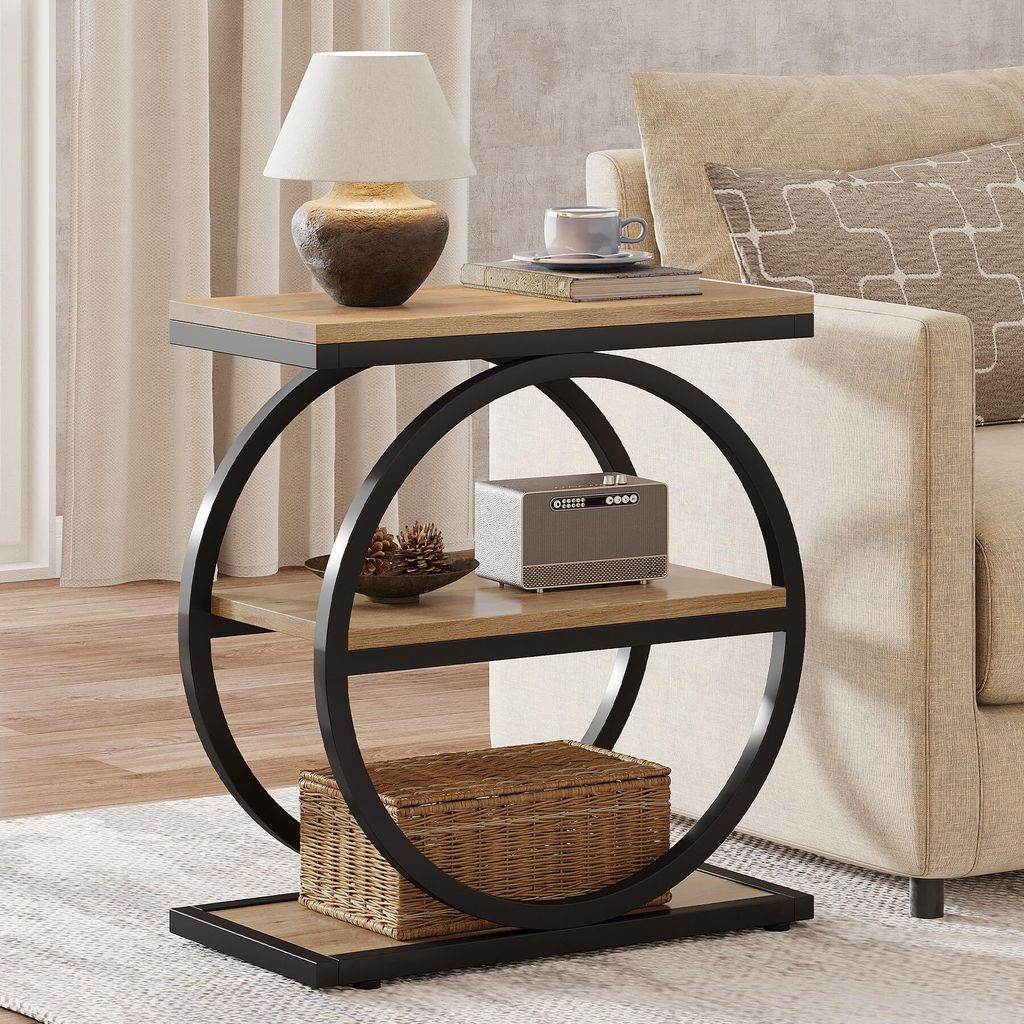 A side table with a lamp, books, and a small speaker next to a sofa.