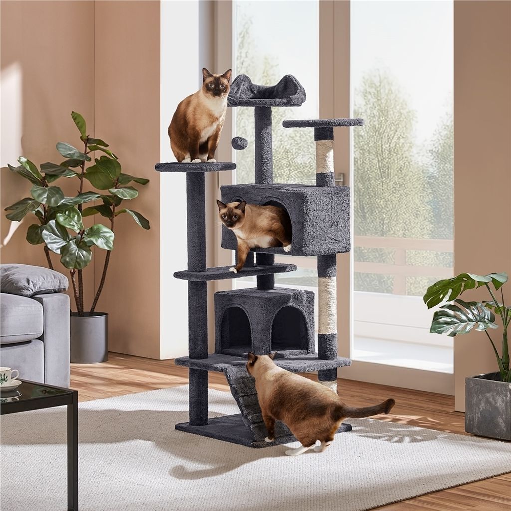 Three cats interact with a multi-level cat tree in a living room setting.