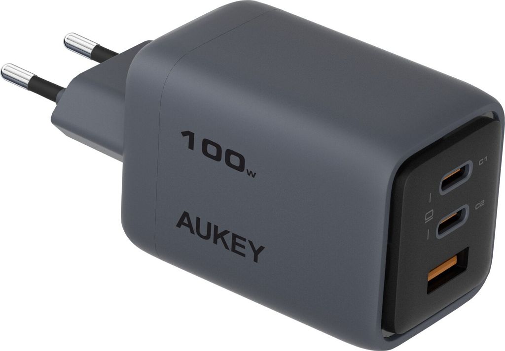 A close-up, angled view of a gray AUKEY 100W PD GaN charger with two USB-C ports and one USB-A port.