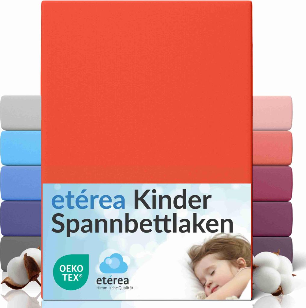 A stack of colorful fitted sheets with a child sleeping on a pillow in the foreground.