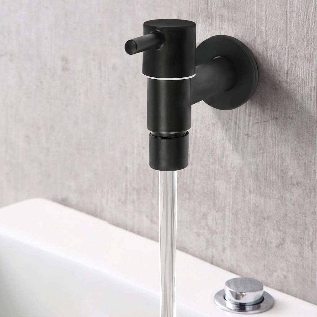 A black wall-mounted faucet with water flowing into a white bathtub.