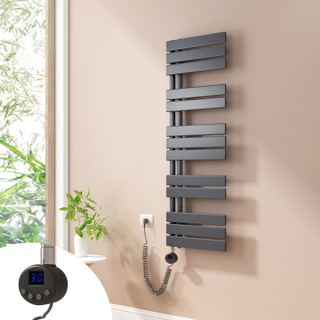 A modern electric towel radiator mounted on a wall next to a window with plants.