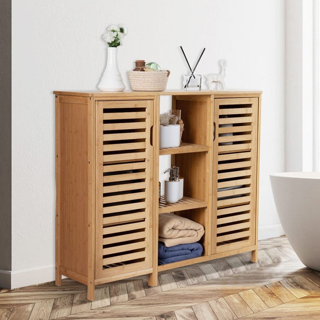 A bamboo bathroom cabinet with slatted doors and open shelving, displaying towels and bathroom accessories.